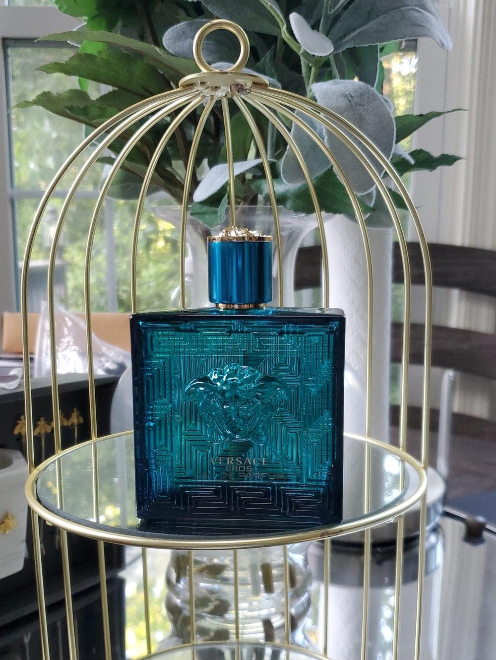 Versace Eros Eau De Parfum for Men. Teal blue glass perfume bottle with gold cap